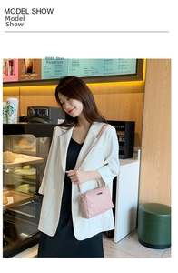 Pink quilted chain bag with diamond stitching pattern shown on a white blazer outfit