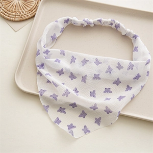 Detail of white chiffon hair tie with purple butterfly print and elastic band on a tray
