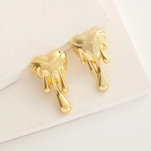 Macro detail of gold-plated heart stud earrings with a unique melting lava fluid effect