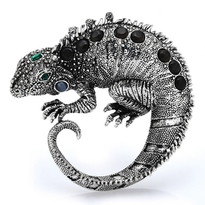 Retro lizard brooch with silver finish and black gemstones on a white background