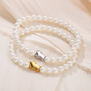 Elegant pearl bracelets with gold and silver pig charms on cream silk fabric base