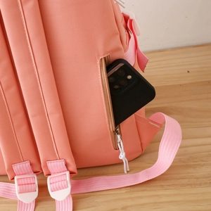 Detailed close-up of a pink backpack back pocket with hidden zipper and anti-theft design