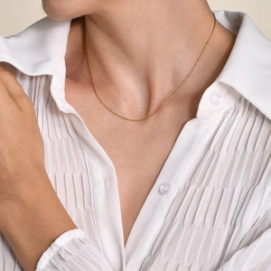 Détail du collier satellite doré de 1mm sur le cou pour un style quotidien minimaliste