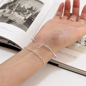 Minimalist S925 sterling silver geometric bracelet and ring set shown on an open book