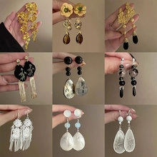 Detailed close-up of nine elegant dangling earrings with pearls and floral designs
