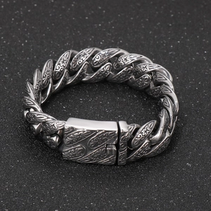 Close-up of vintage floral engraved stainless steel Cuban chain bracelet for men