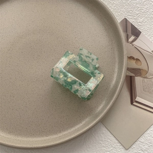 Dettaglio della molletta quadrata con motivi a conchiglia verde menta in acetato
