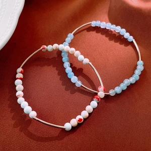 Close-up of aquamarine beads and marble texture bracelets with metallic bar details