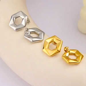 Macro view of geometric hexagonal earrings in polished gold and silver finishes