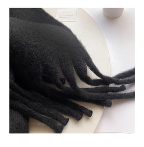 Detailed close-up of soft black mohair scarf featuring elegant long tassel fringe textures