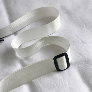 Detail of the white nylon fabric strap with black plastic buckle for crossbody bag
