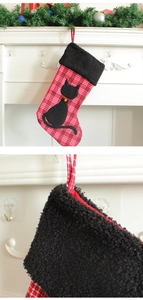 Détail d'une chaussette de Noël écossaise rouge avec applique chat et clochette dorée