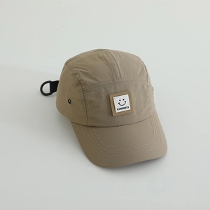 Close-up of khaki quick-dry baseball cap with kindness smiley patch and metal eyelets