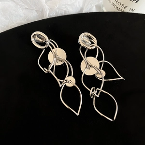 Detailed close-up of silver hollow round earrings on premium black velvet background