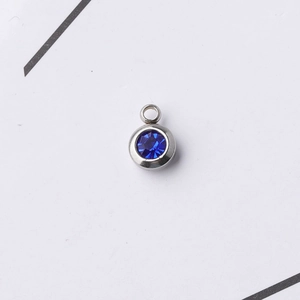 Close-up of a 6.5mm stainless steel round pendant with a blue birthstone for DIY jewelry