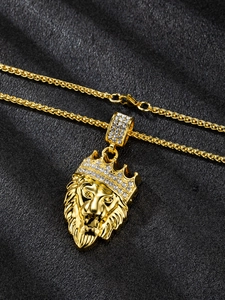 Close-up of golden lion head pendant with sparkling rhinestones on black fabric