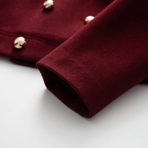 Close-up of burgundy wool jacket featuring premium round golden metal buttons on sleeves