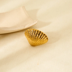 Macro shot of 18K gold plated stainless steel ring with detailed shell texture on fabric