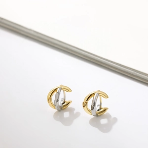 Minimalist gold and silver two-tone crisscross hoop earrings on a white surface