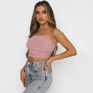 Détail du crop top rose en maille côtelée avec cordon latéral et effet froncé