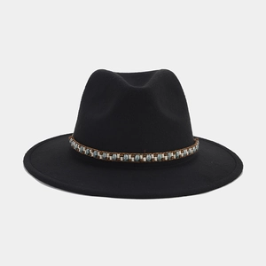 Detalle de sombrero fedora de fieltro negro con una banda decorativa étnica de cuentas