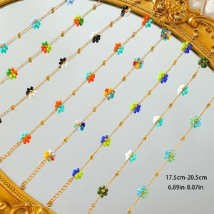 Minimalist 18K gold-plated beaded floral bracelets on a mirror surface for women