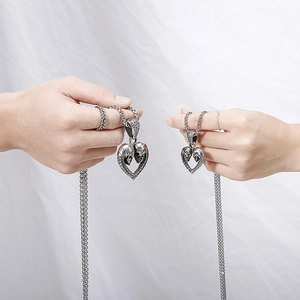 Collier rétro en acier titane avec pendentif cœur double crâne pour couple tenu en main