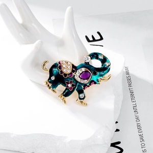 Ethnic elephant brooch with green enamel and sparkling rhinestones on golden alloy base