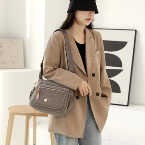 Waterproof nylon crossbody bag in grey-brown featuring multiple zipper compartments