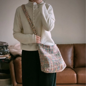 Colorful woven knit crossbody bag with vibrant tweed texture and wide shoulder strap