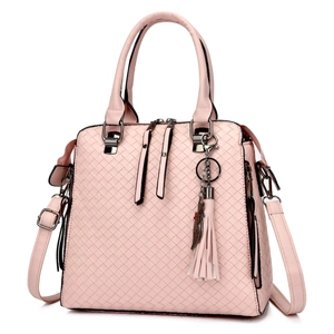 Detail of pink woven leather handbag with decorative fringe and metallic pendant accents