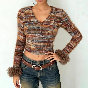Macro detail of multicolored striped knit fabric with faux fur trim on long sleeves