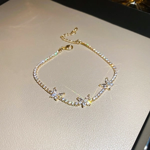 Dettaglio del bracciale a farfalla dorato con zirconi brillanti e catena regolabile