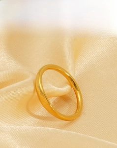 Close-up of sleek 18K gold plated stainless steel ring on a soft silk background