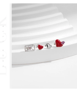 Detailed view of S925 sterling silver heart and envelope stud earrings on white props