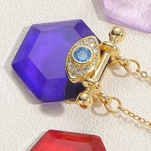 Macro shot of evil eye pendant with blue crystal and zircons on gold chain necklace
