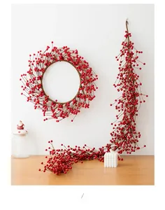 Detail of red artificial berry wreath and garland for Christmas window decoration