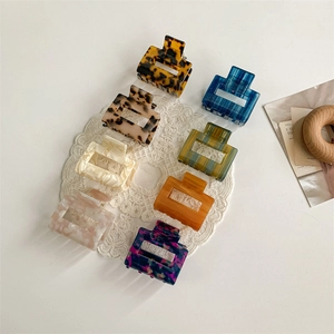 Eight premium acetic acid square hair claws in marble and leopard patterns on a lace mat