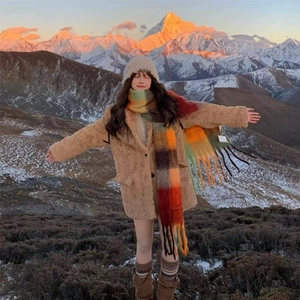 Chic winter rainbow plaid scarf with long tassels and brown plush coat in snow mountains