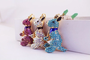 Close-up of three kangaroo keychains with sparkling rhinestones in purple and blue colors