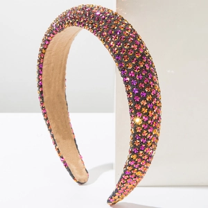 Detail of sponge headband with shimmering colorful rhinestones on a white stand
