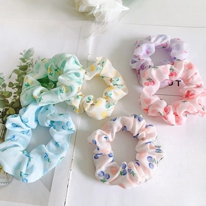 Detailed view of 6-piece assorted fruit print scrunchies in pastel colors on floral background