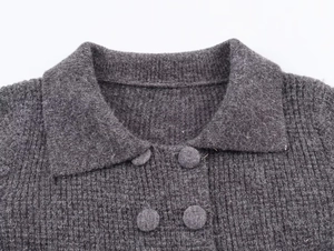 Close-up of dark grey double-breasted knit cardigan with lapel collar and ribbed texture