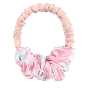 Detailed view of pink heatless hair curler made of soft satin fabric with tie-dye pattern