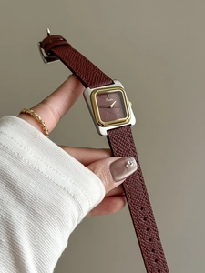 Gros plan d'une montre vintage pour femme avec bracelet en cuir brun et lunette dorée