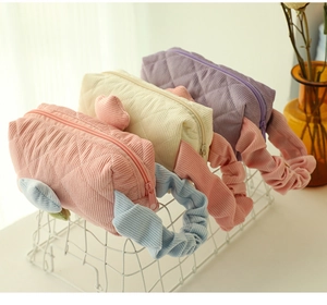 Detailed close-up of quilted corduroy cosmetic bags in pink, beige and purple colors