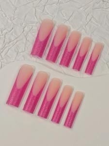 Macro shot of long coffin press-on nails with rose red glitter french gradient detail