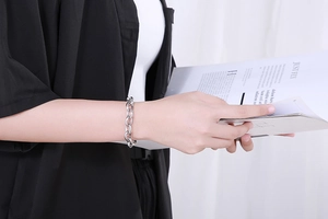 Close-up of polished silver titanium steel chunky chain bracelet on model's wrist