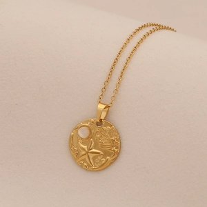 Detailed macro shot of gold turtle pendant with shell relief and embedded pearl