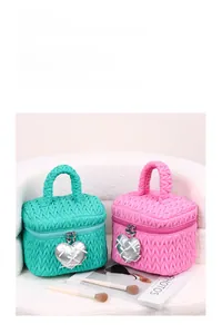 Close-up of quilted texture cosmetics bag with heart charms in mint green and pink